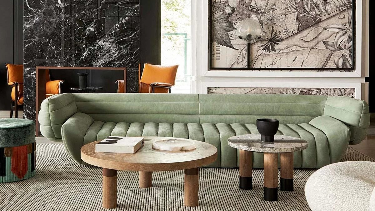 Dexter Sofa along with several unique pieces of furniture in a grand stately living room with marble wall and large artwork  