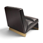 A modern low-profile lounge chair with dark brown leather upholstery and a light natural wood base, shown from a three-quarters angle on a white background.