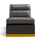 A modern low-profile lounge chair with a dark gray leather seat and backrest, supported by a dark base with a mustard yellow bottom trim, shown against a plain white background.