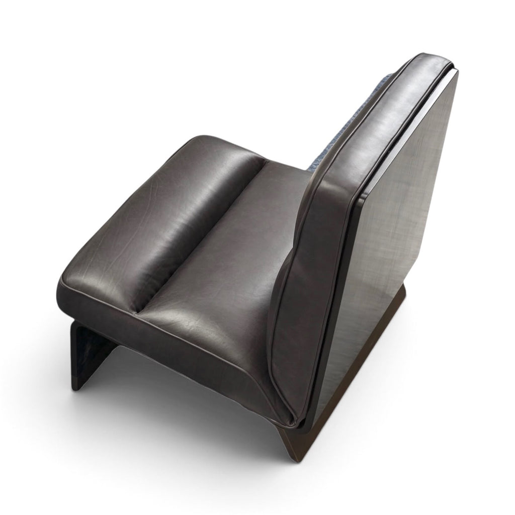 A modern low-profile armchair with dark brown leather cushions and a dark wood base, shown from a high-angle perspective on a white background.