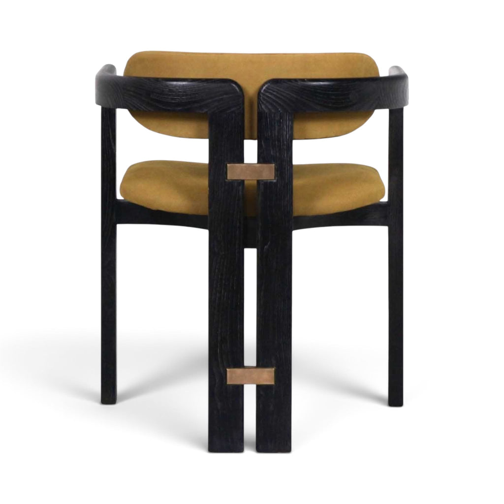 The Pamplona dining chair with a black wood frame and mustard yellow velvet upholstery, shown from the back | Nue Modern