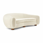 Three-quarter view of the curved sherpa Polar Bear Sofa showing its rounded arms and short wooden legs | Nue Modern