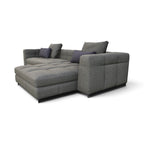 A modern gray fabric sectional sofa with a chaise lounge, featuring tufted cushions and three dark gray accent pillows, shown on a plain white background.