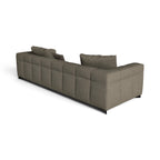 A modern sectional sofa in a textured taupe fabric, featuring a tufted grid pattern on the backrest and seat, with two matching throw pillows, shown from a three-quarters perspective on a white background.