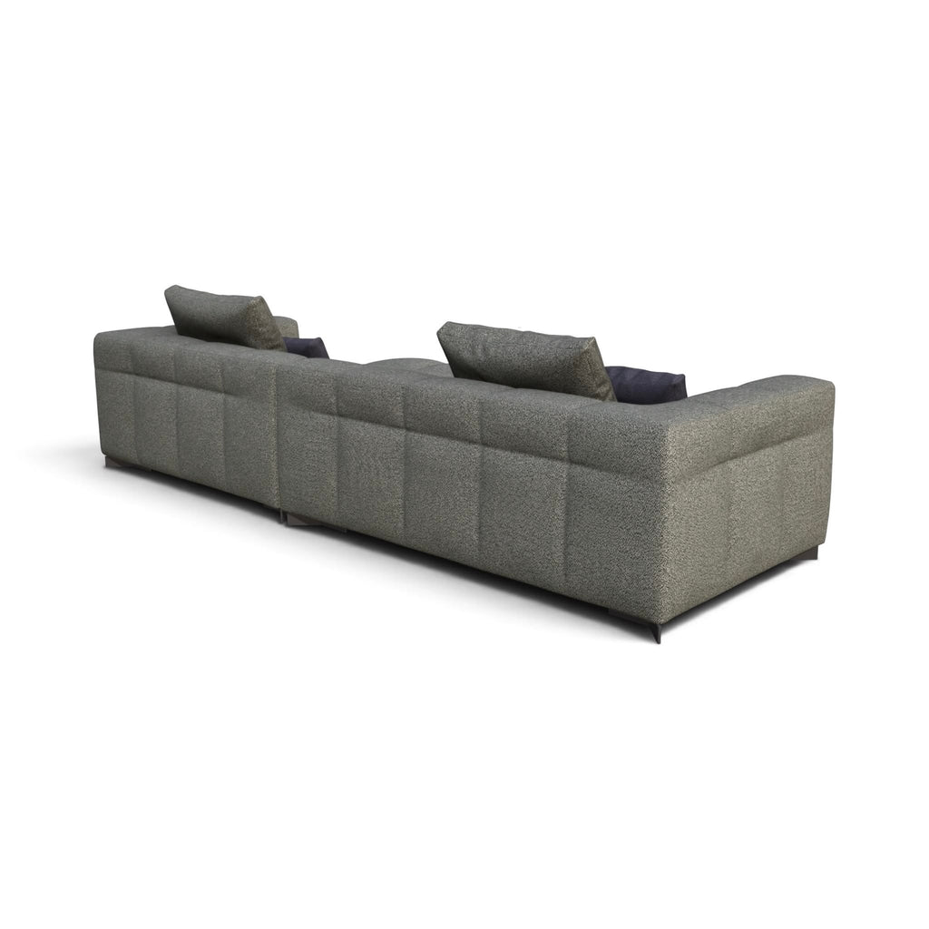A modern sectional sofa in textured gray fabric with tufted channel stitching, shown from a three-quarters perspective on a white background.