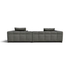 A modern modular sectional sofa in textured gray fabric with tufted square back cushions and two matching gray throw pillows, shown from a straight-on perspective against a plain white background.
