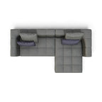 A top-down view of a modern gray sectional sofa with a chaise lounge and two dark purple accent pillows, isolated on a white background.