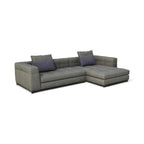 A modern L-shaped sectional sofa upholstered in textured gray fabric, featuring two dark gray accent pillows, shown on a plain white background.