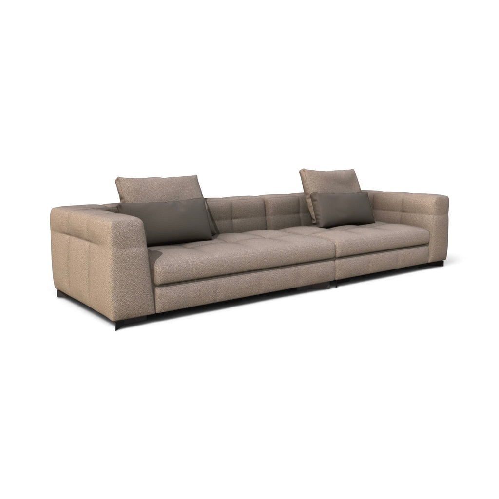 A modern three-seater sofa upholstered in a textured light beige fabric, featuring two dark gray throw pillows, shown on a plain white background.