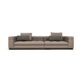 A modern two-seater sofa upholstered in a textured taupe-beige fabric, featuring two dark gray throw pillows and a low black base, shown against a plain white background.