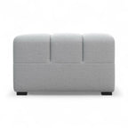 A modern light grey upholstered Tufty-TF005, viewed from the side, with dark square feet, set against a white background