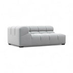 A modern light gray tufted chaise lounge sofa with a low, boxy silhouette and dark feet, shown against a plain white background.